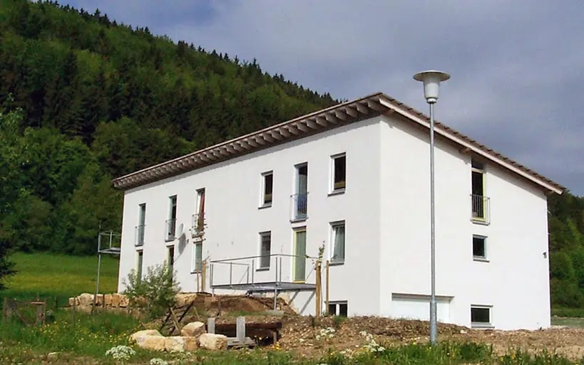 Modernes Einfamilienhaus im Landhausstil mit Satteldach, gebaut mit dem MAGU Bausystem auf einem Hanggrundstück im Grünen.