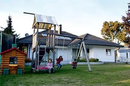 Modernisiertes MAGU Bausatzhaus mit Garten und spielenden Kindern