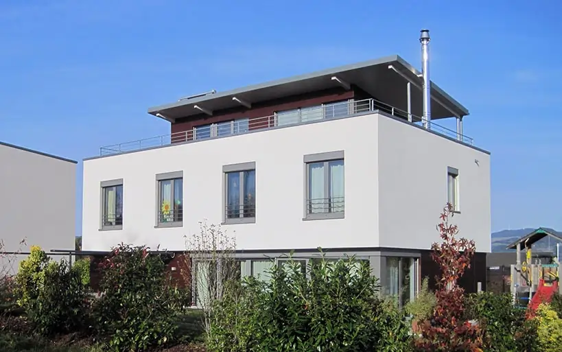 Modernes Flachdachhaus mit Dachterrasse und großen Fenstern, realisiert mit dem MAGU Bausatzsystem.